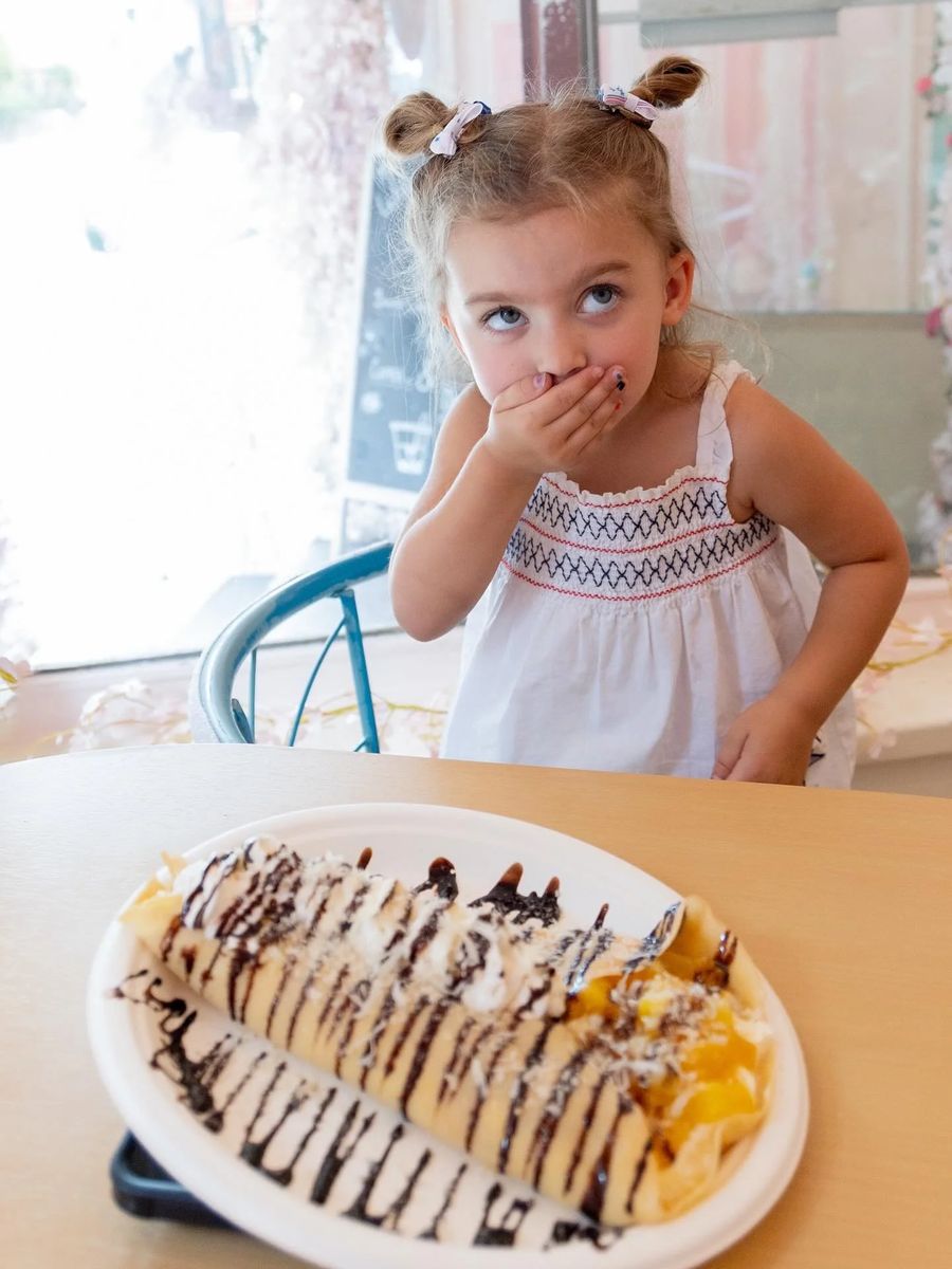 A young guest enjoying crepes at Ma's